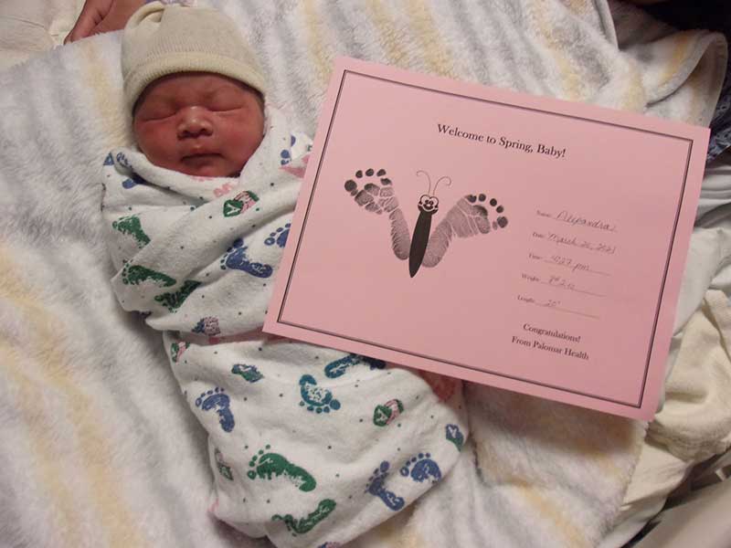 Newborn Baby with a card with birth information