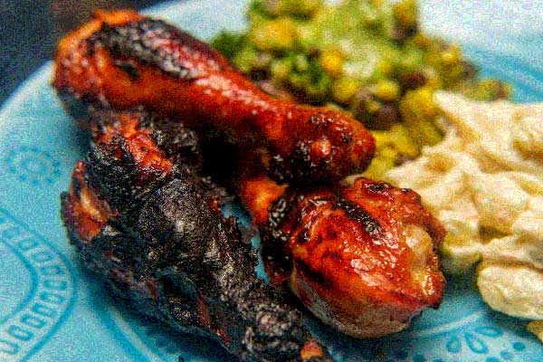 Charred chicken drumsticks on a plate of food
