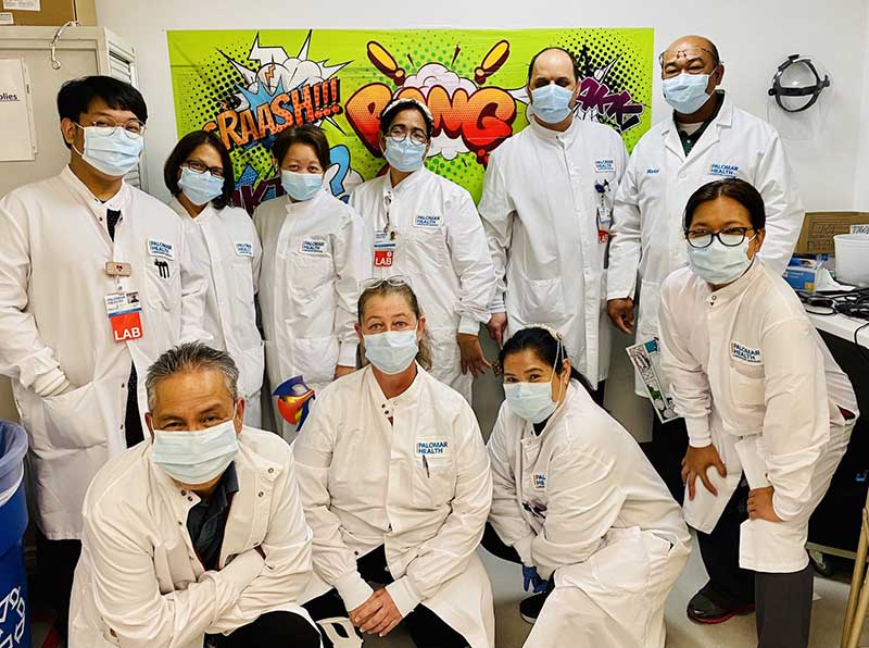 Lab team with a comic-inspired banner behind them